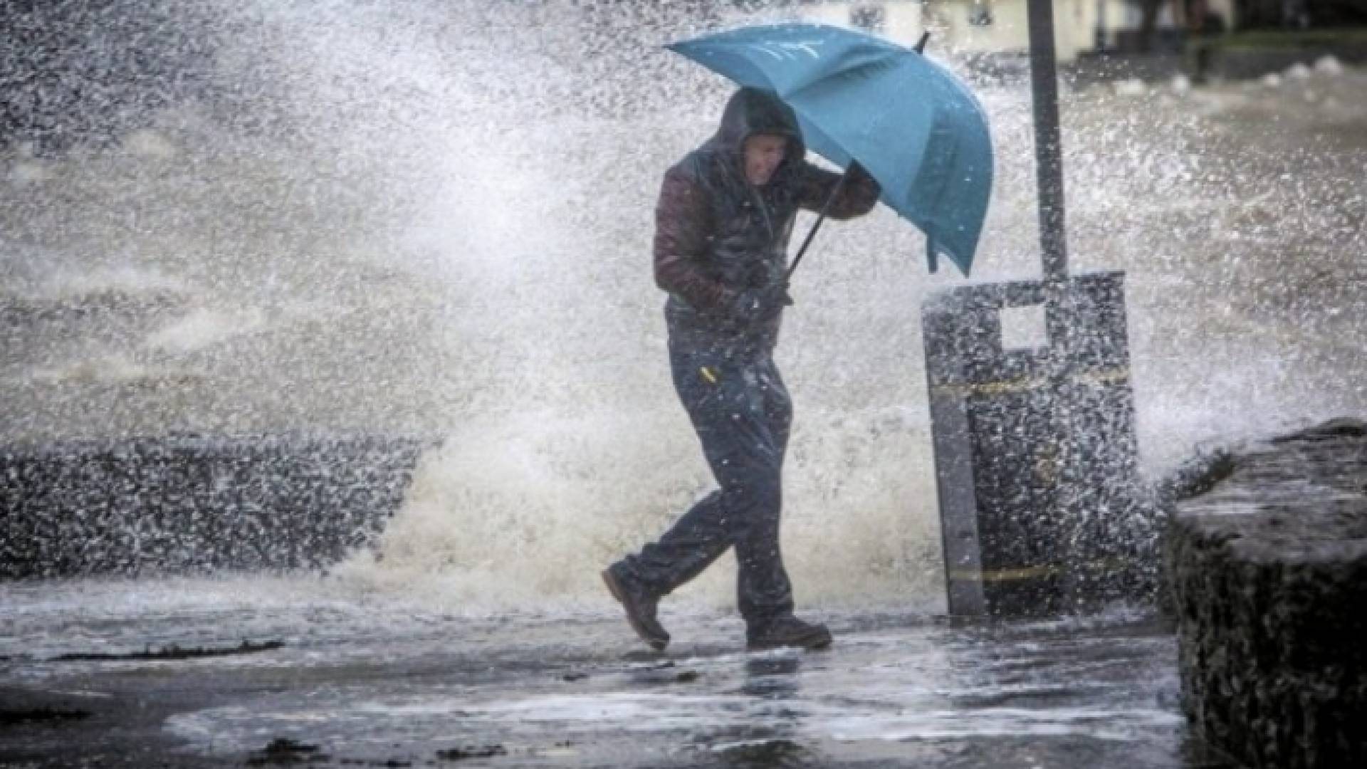 رجل يحمل مظلية خلال تساقط غزير للأمطار