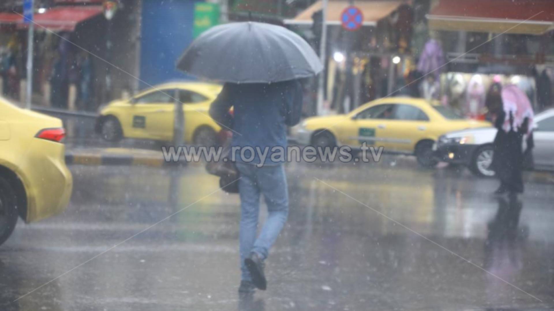 رجل يسير في أجواء ماطرة