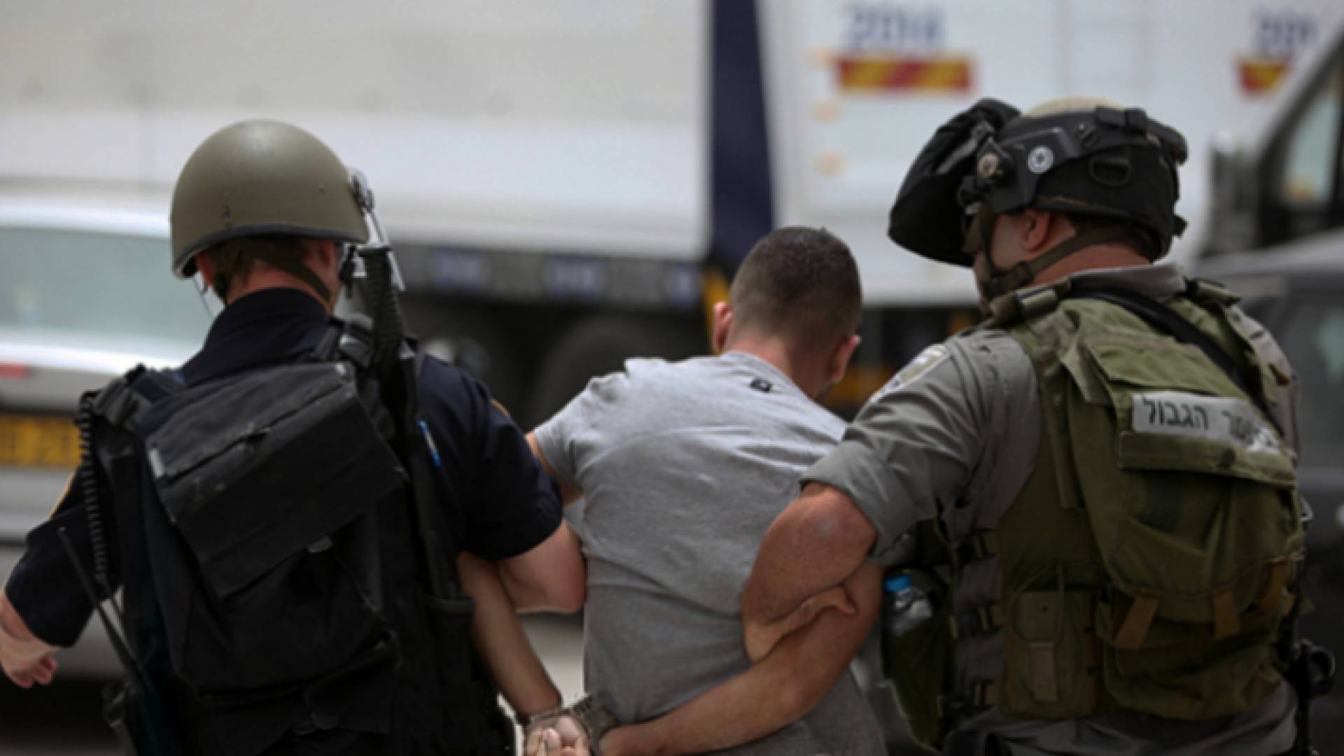 صورة أرشيفية لعنصرين في قوات الاحتلال يعتقلان شابا فلسطينيا