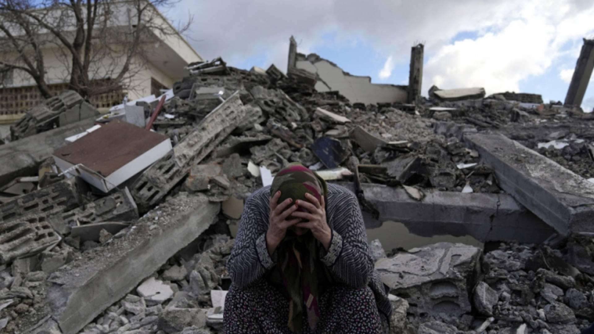 سيدة مكلومة على أنقاض عمارة تعرضت للانهيار جراء زلزال ضرب تركيا وسوريا