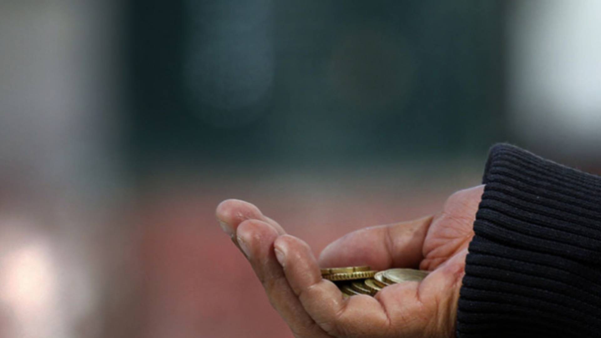 صورة توضيحية لنقود بيد متسول