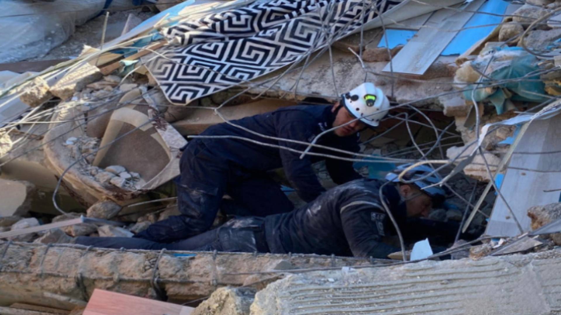 عنصران في فريق البحث والإنقاذ الأردني الدولي يبحثان تحت الأنقاض