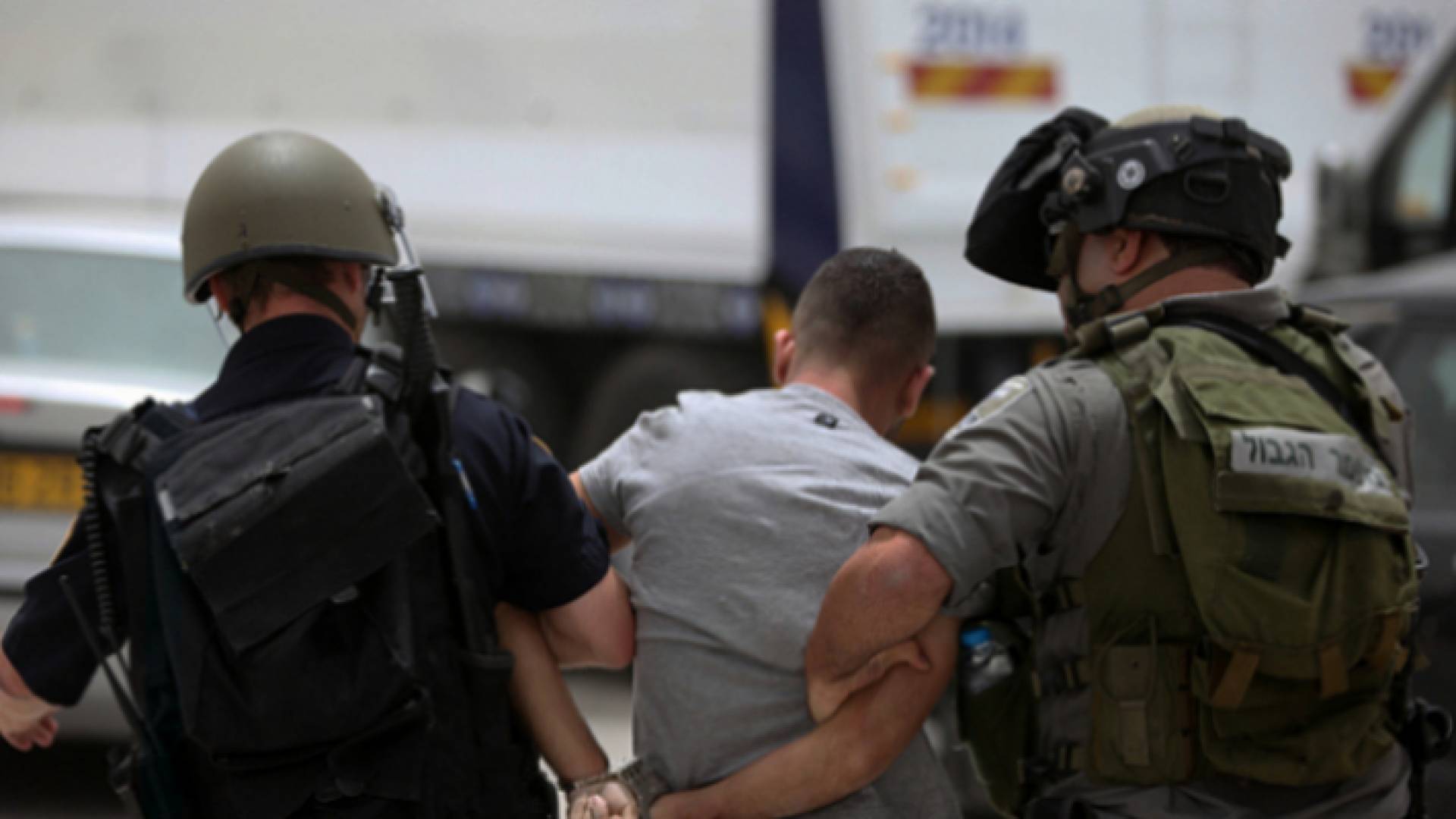 صورة أرشيفية لعنصرين في قوات الاحتلال يعتقلان شابا فلسطينيا