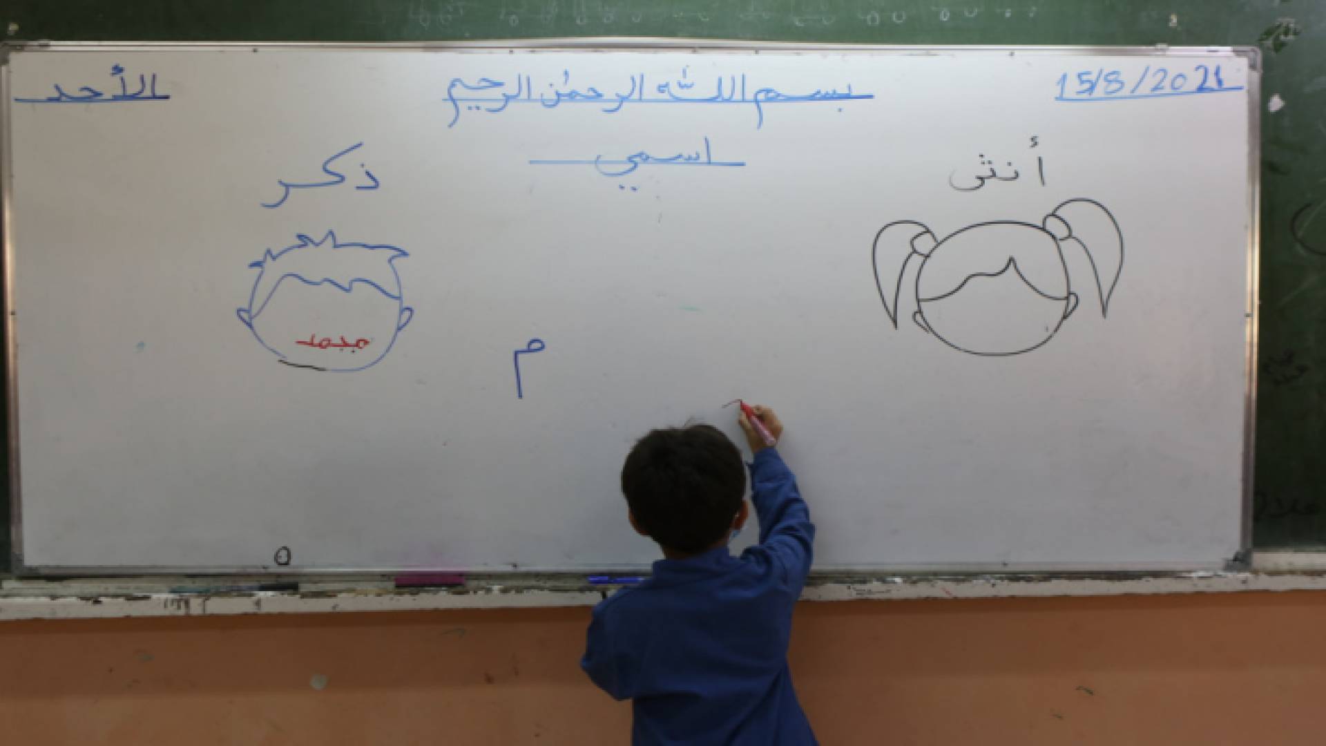 طالب يكتب على السبورة