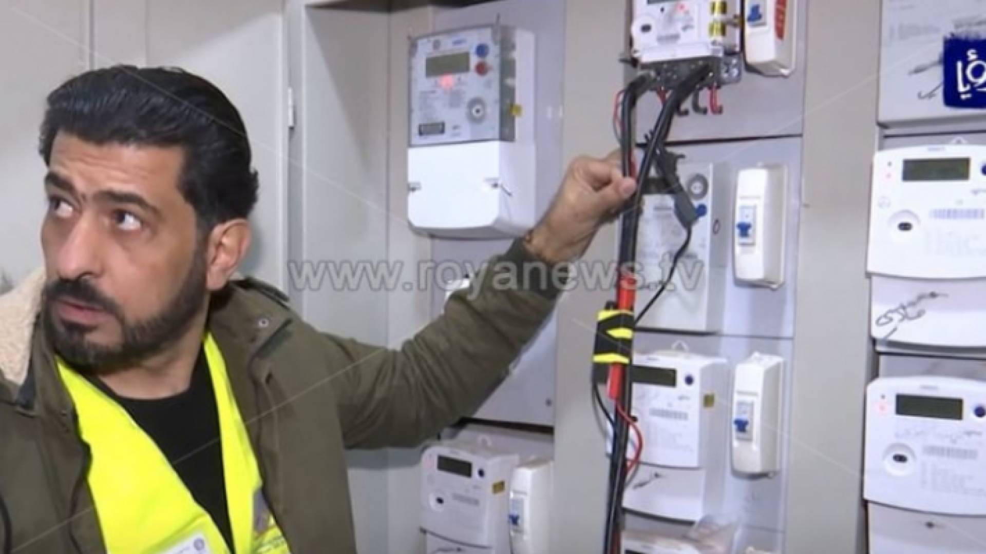 شخص يقف أمام عدادات الكهرباء