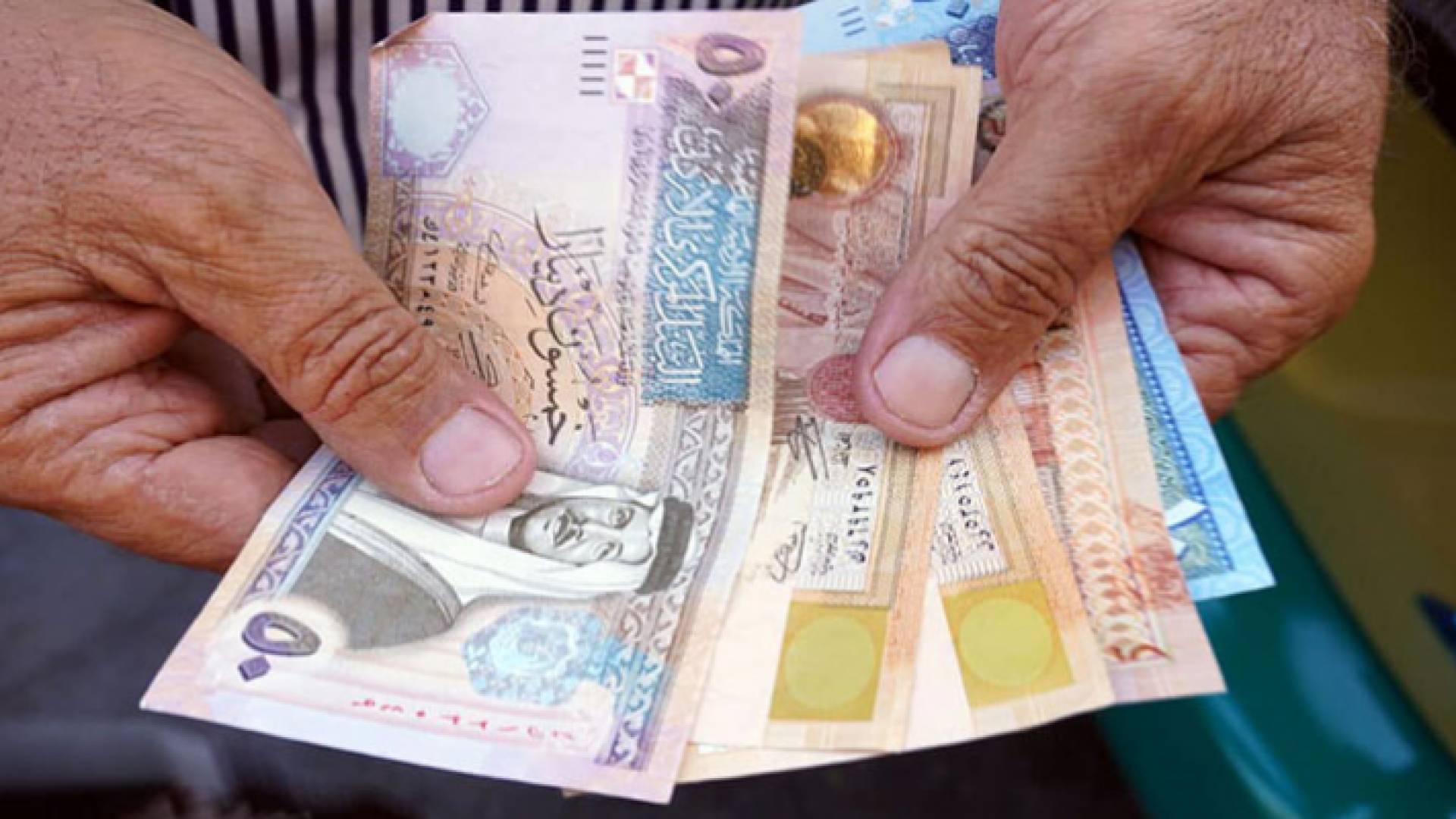 صورة تعبيرية لشخص يحمل نقود