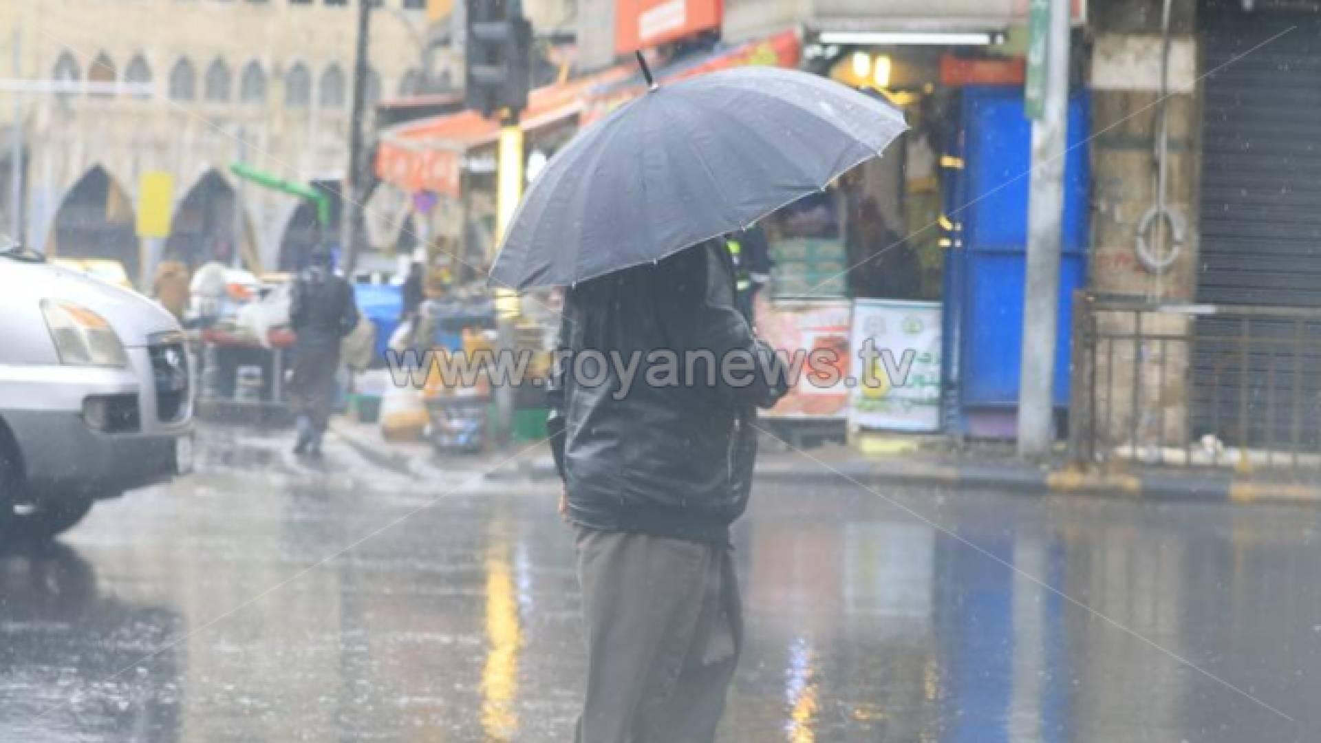 شخص يحمل مظلة في أحد شوارع العاصمة عمان