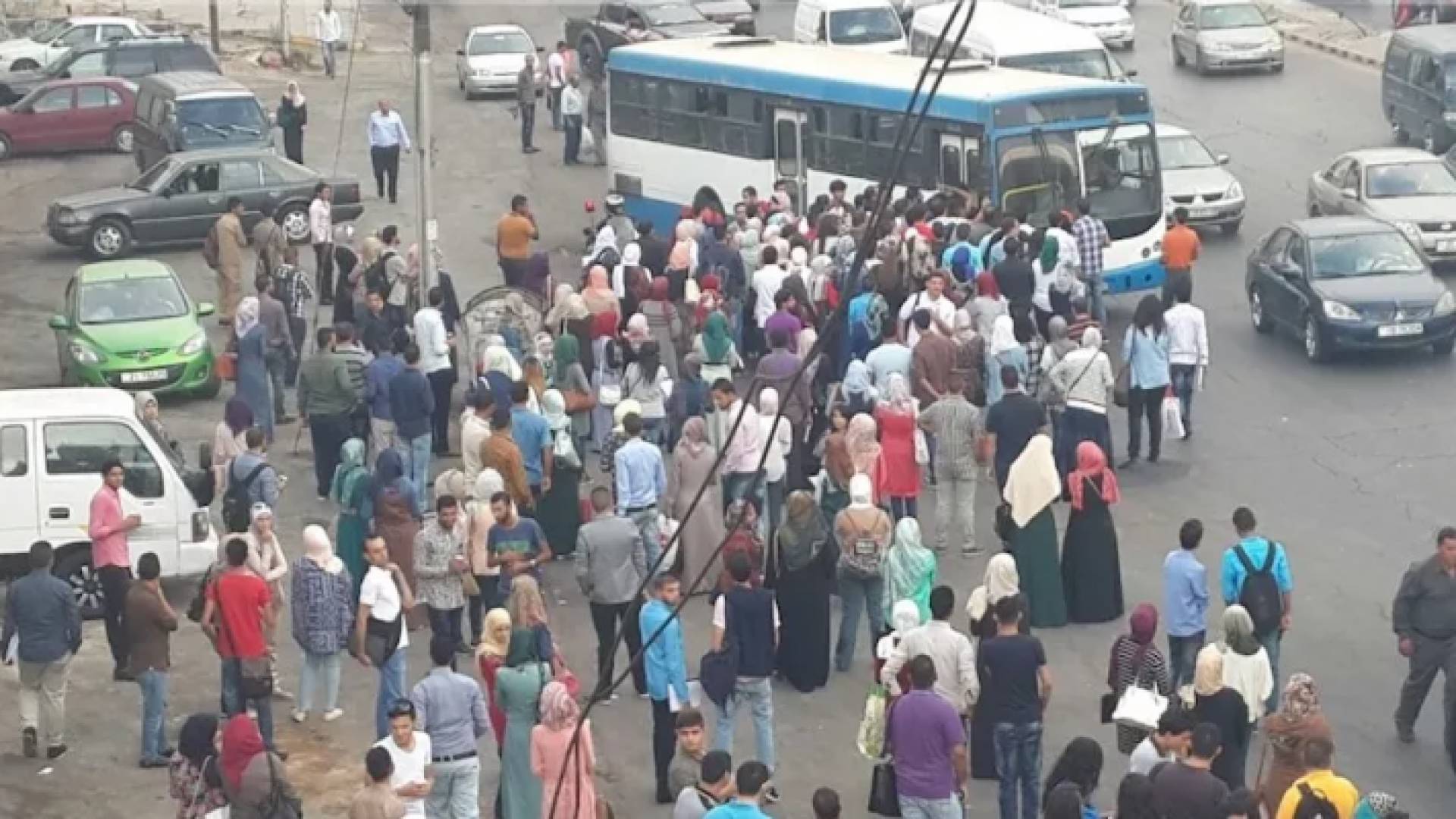 مواطنون ينتظرون حافلة في موقف حافلات بالعاصمة عمان - أرشيفية