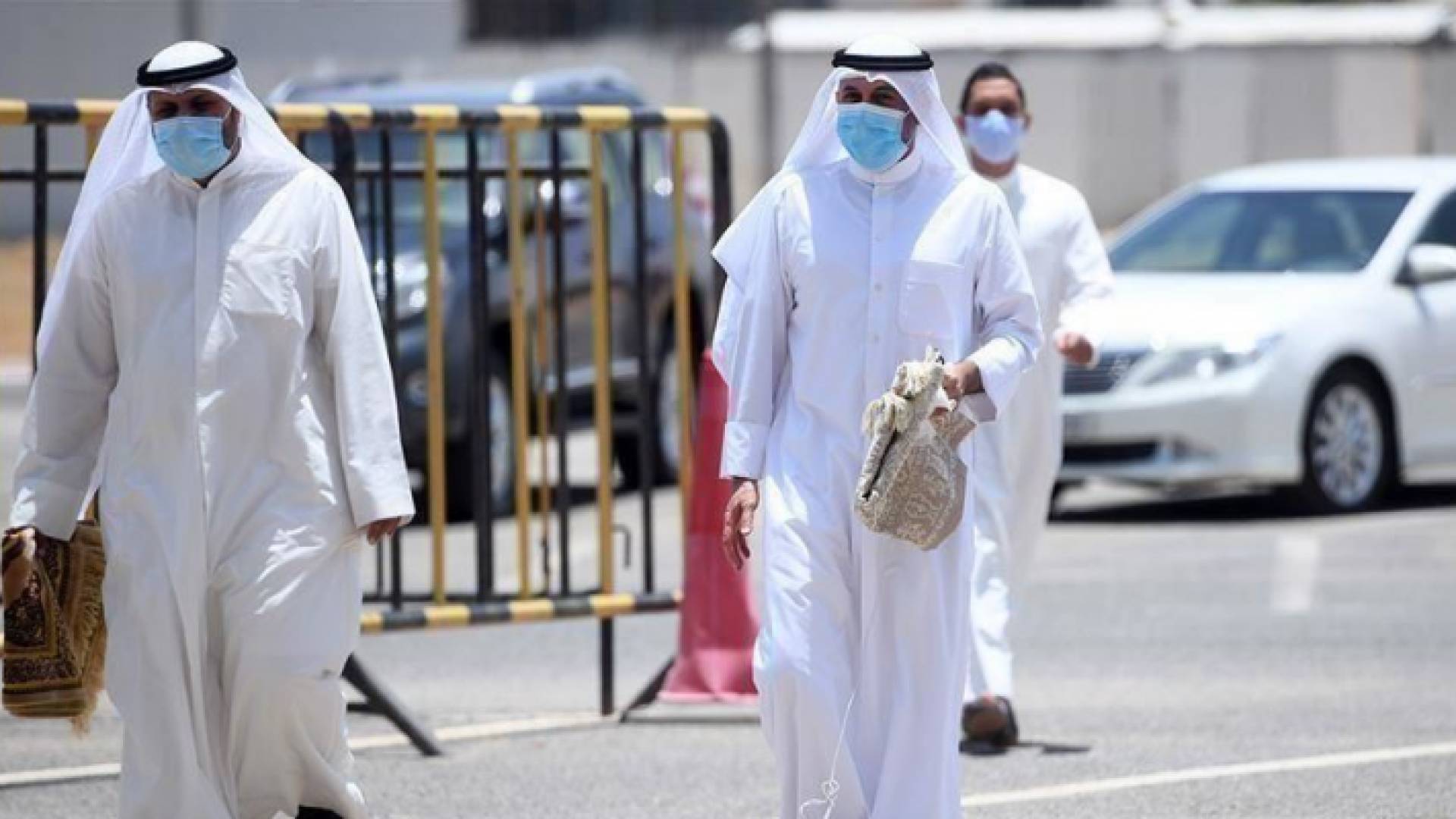 أشخاص يرتدون الكمامة في الطريق العام