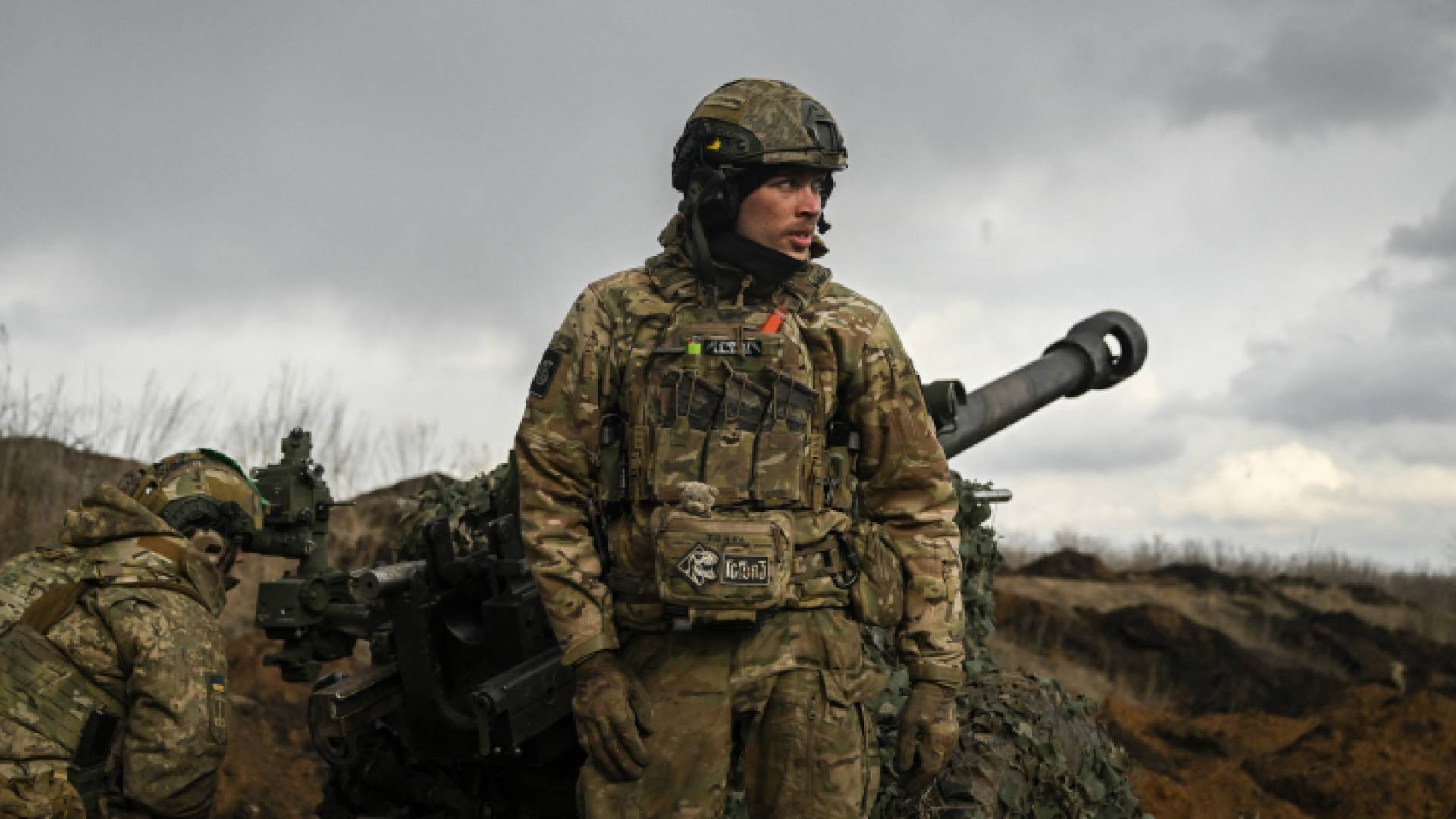 جندي أوكراني يقف أمام مدفع هاوتزر عيار 105 ملم