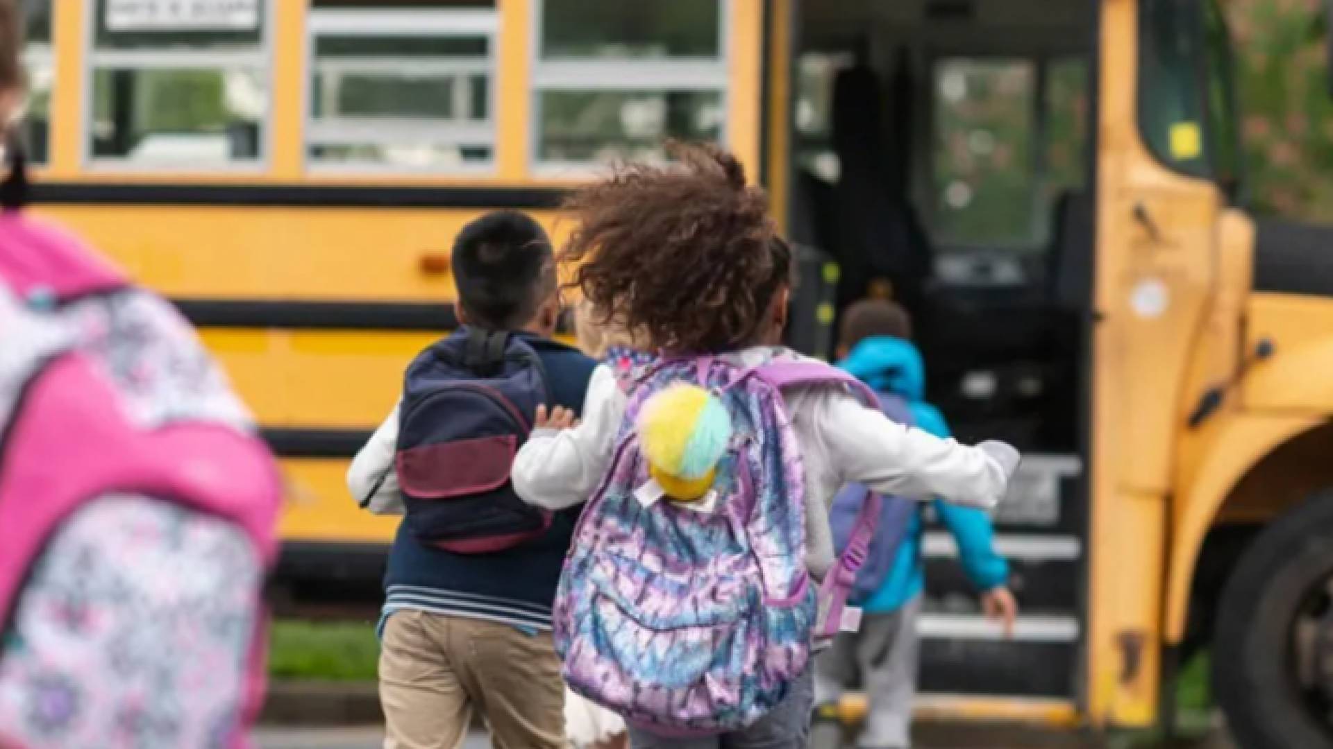 طفلة تركض نحو حافلة مدرسية