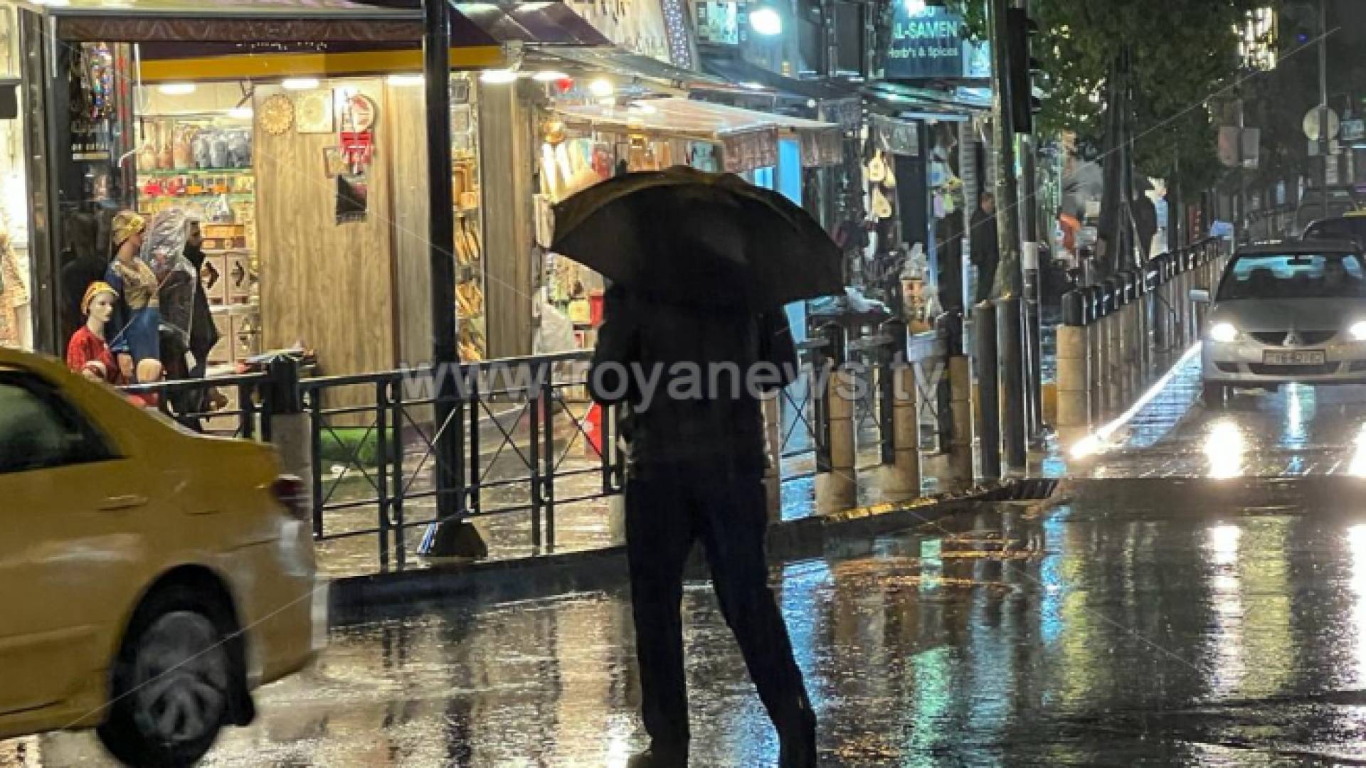 شخص يحمل مظلة في أحد شواع العاصمة عمان