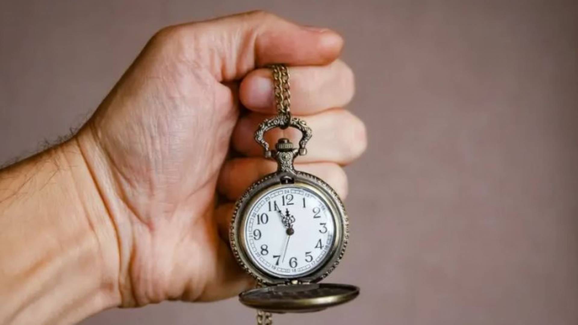 شخص يحمل ساعة لمعرفة الوقت "تعبيرية"