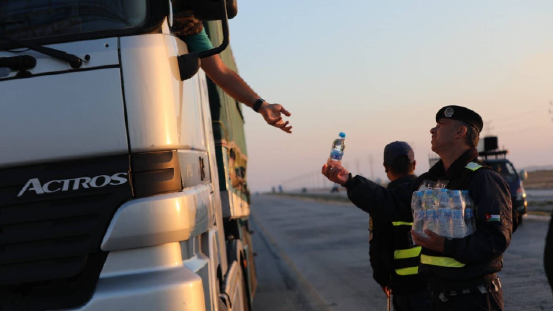 رجال الأمن العام يوزعون مياه الشرب على السائقين على الطرق الخارجية