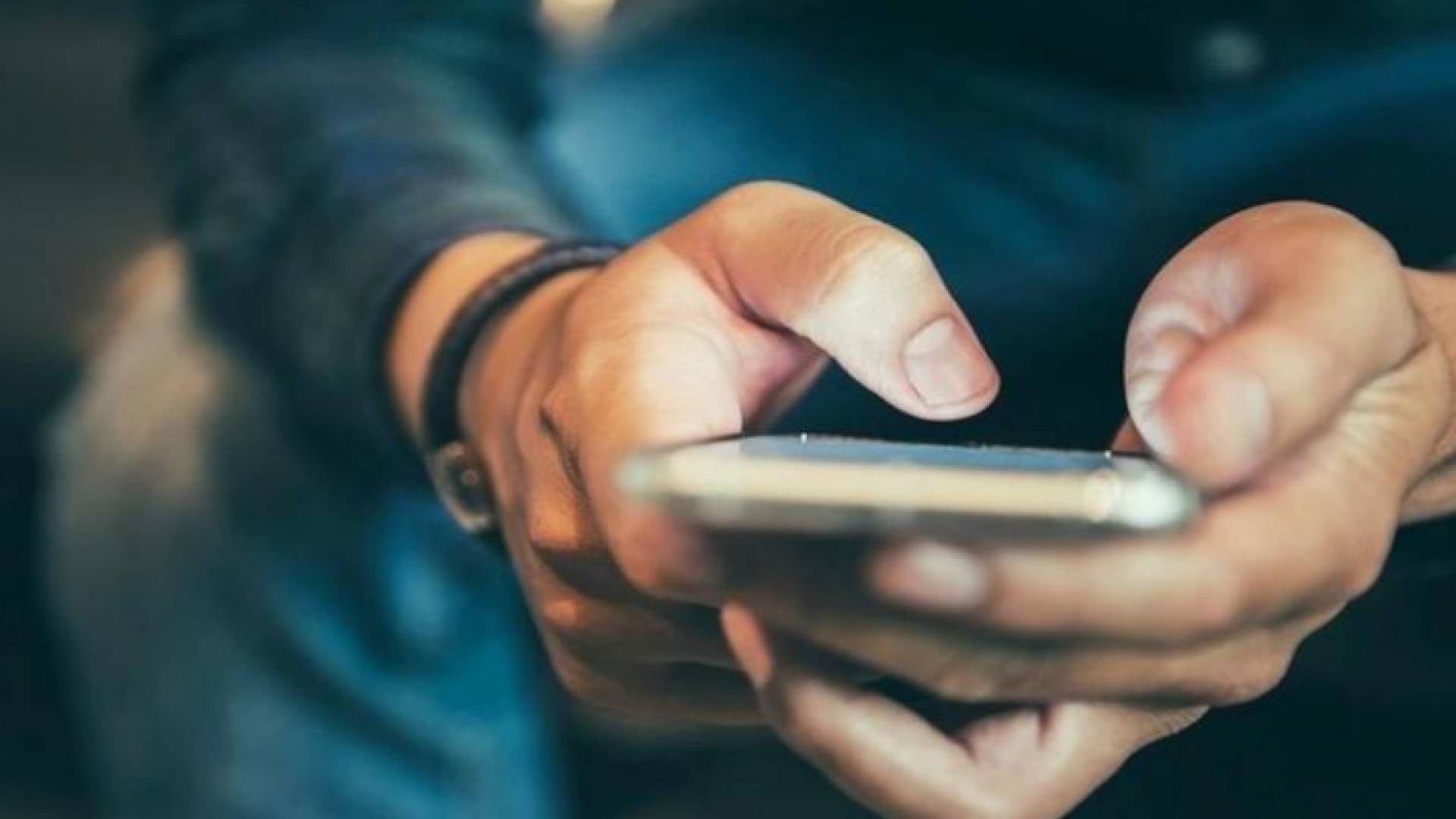 شخص يحمل هاتفا ذكيا