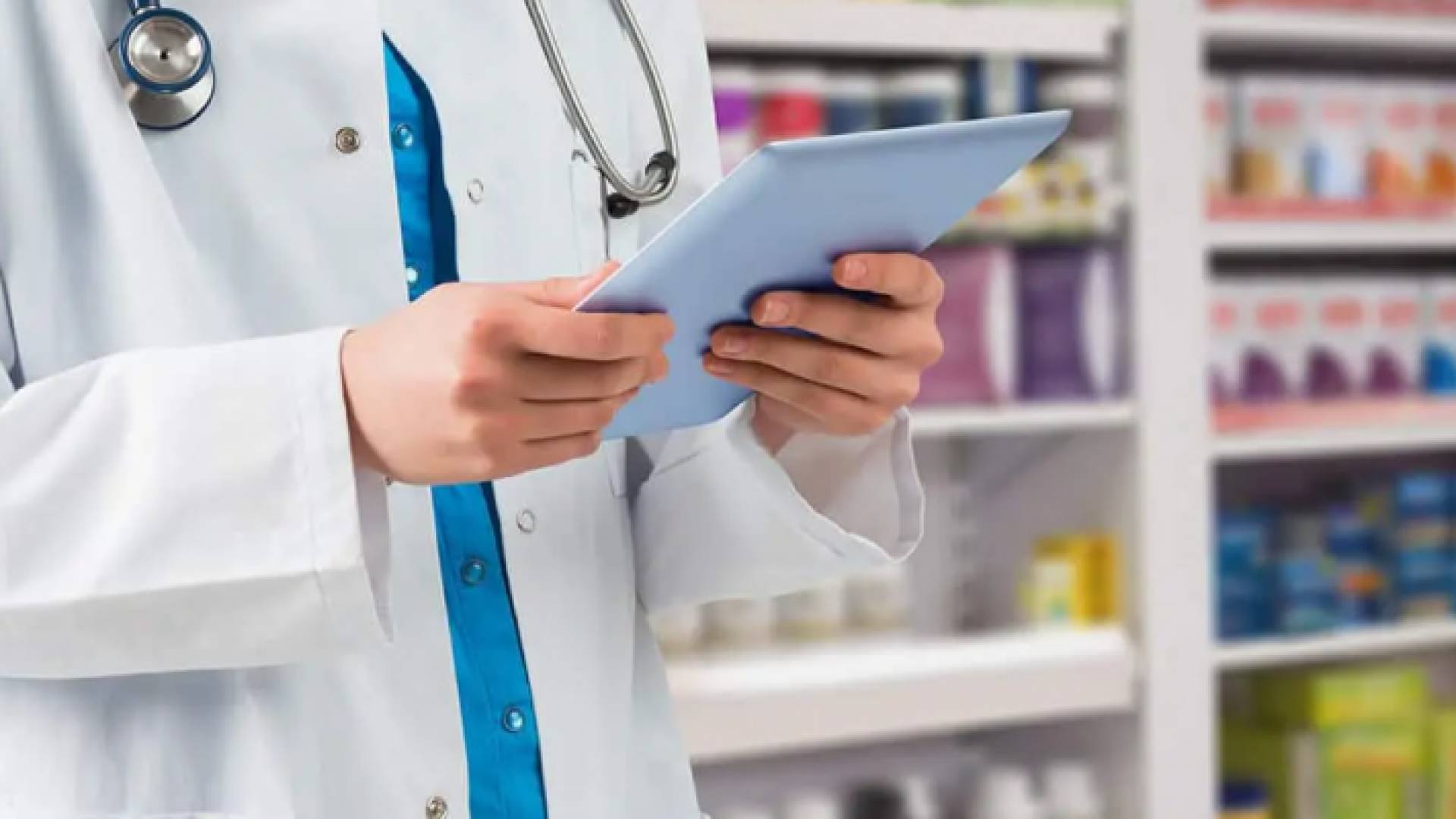 أحد الكوادر الطبية يحمل أوراق وحوله أدوية