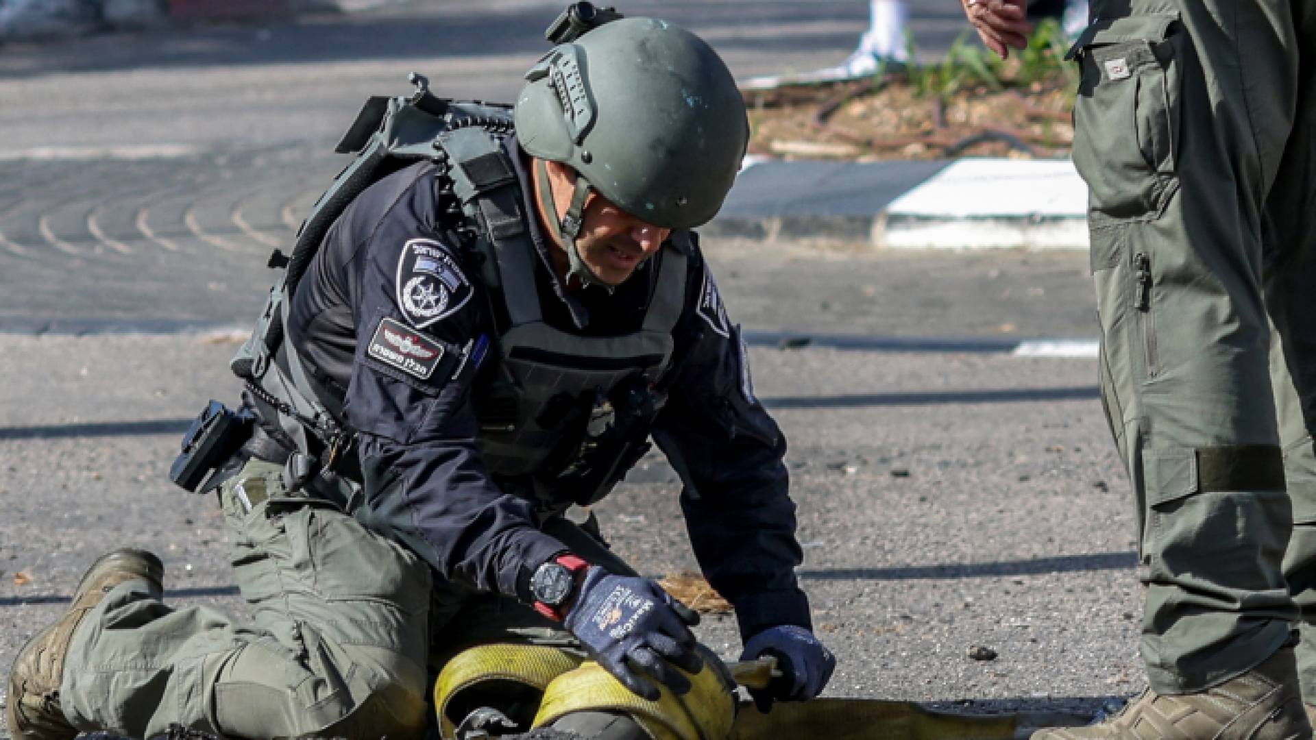 عنصر من شرطة الاحتلال يتفقد بقايا قذيفة أطلقت من لبنان