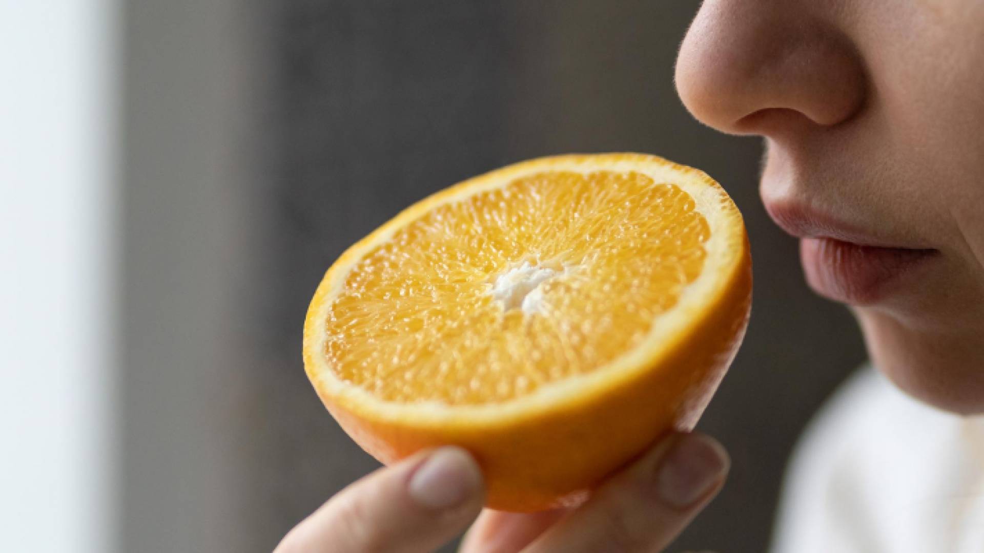 صورة امرأة تشتم رائحة البرتقال