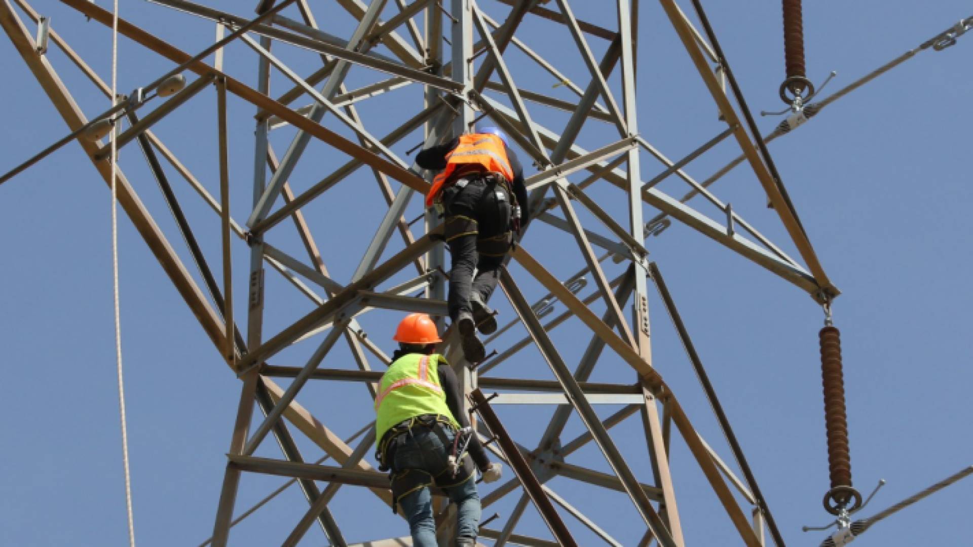 صورة أرشيفية لعاملين في شركة توزيع الكهرباء خلال إجراء أعمال صيانة