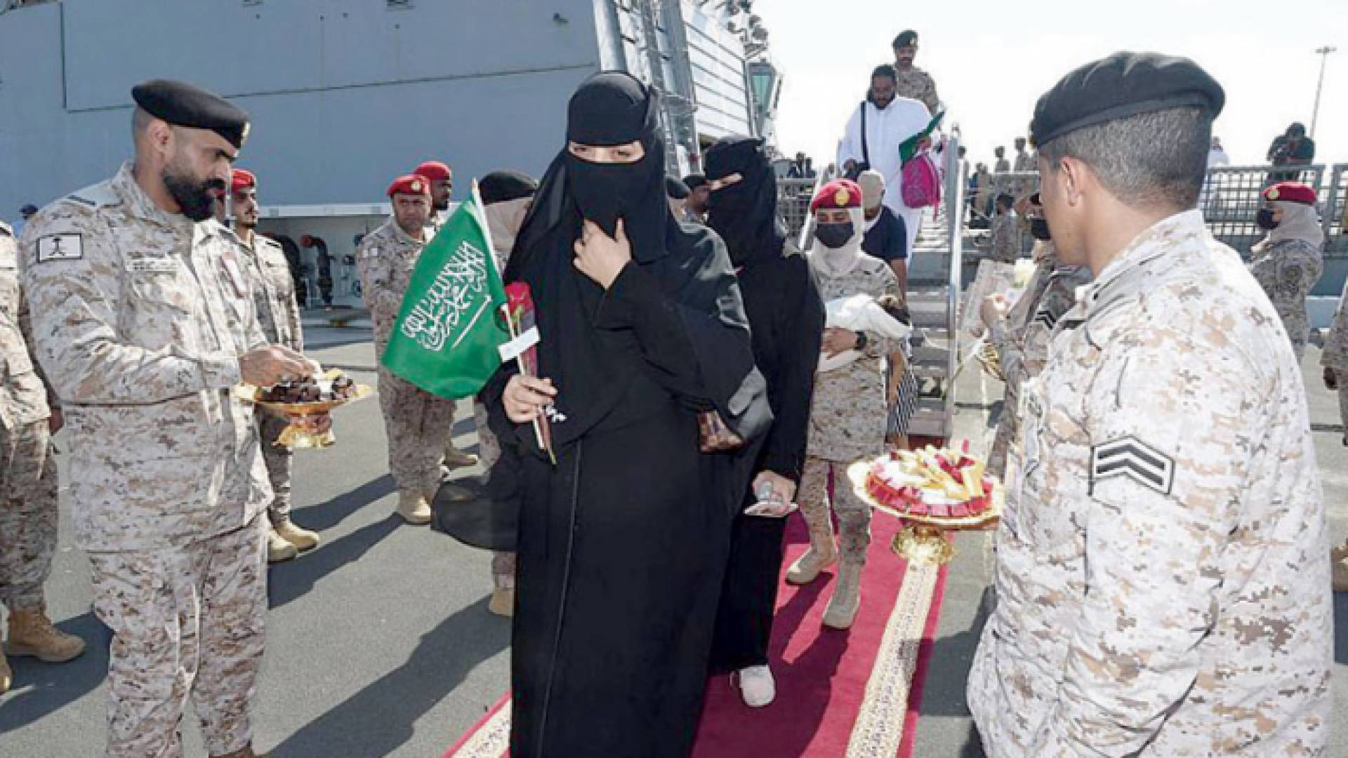 رجال الأمن السعودي يستقبلون أشخاص بعد إجلائهم من السودان