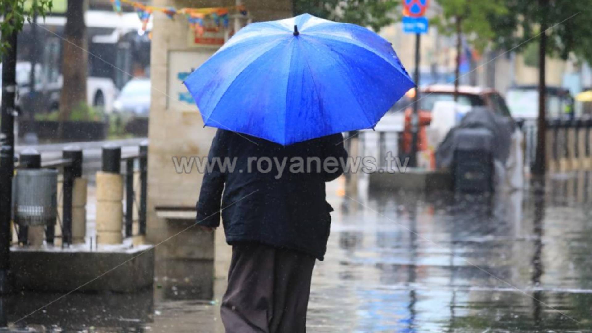 رجل يسير في أجواء ماطرة - ارشيفية
