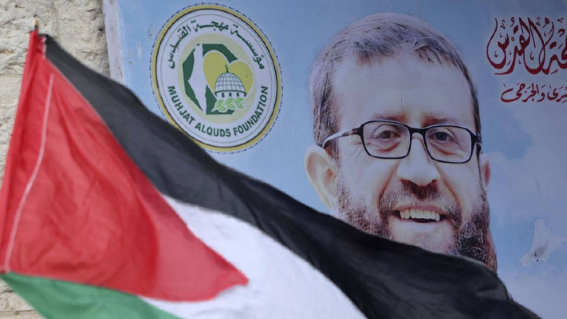 صورة للشهيد خضر عدنان أمامه العلن الفلسطيني