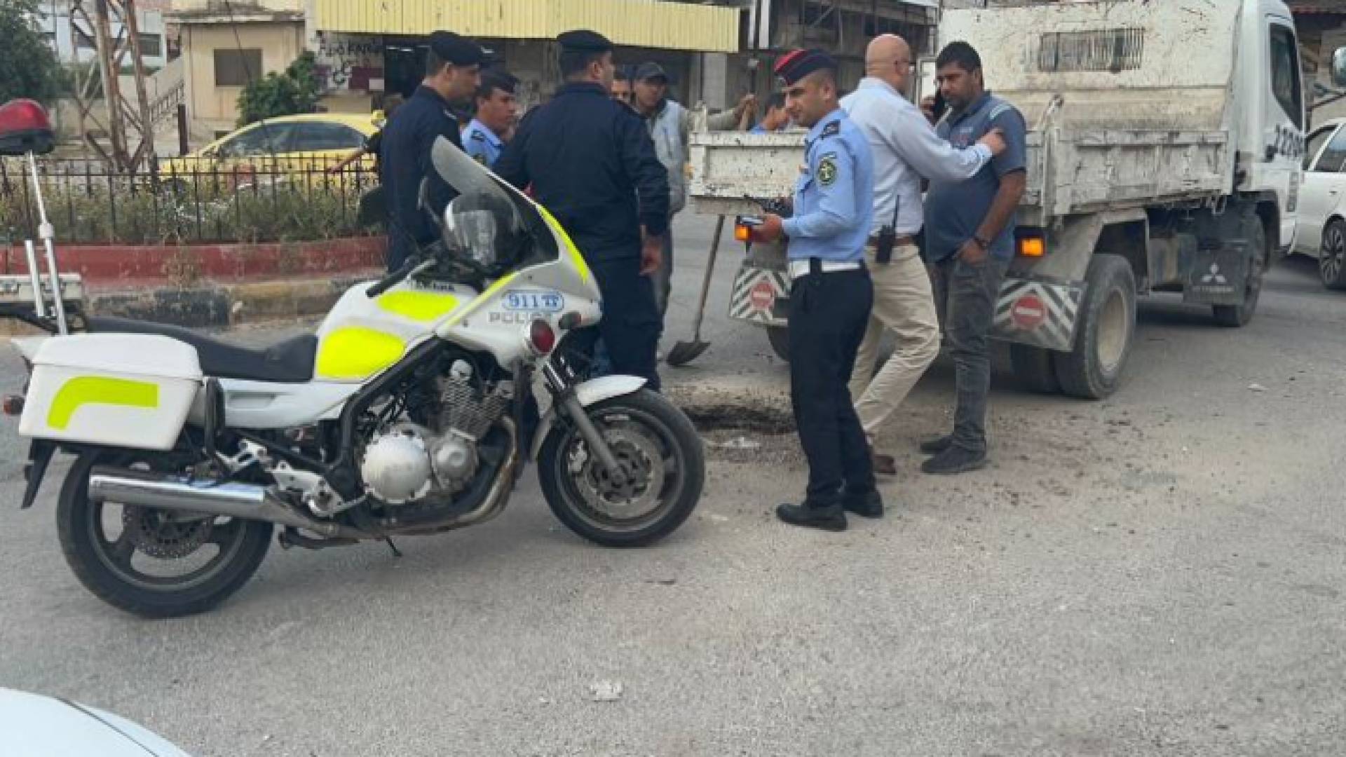 كوادر السير وبلدية إربد بالقرب من مكان الحفرة للتعامل مع الحادثة