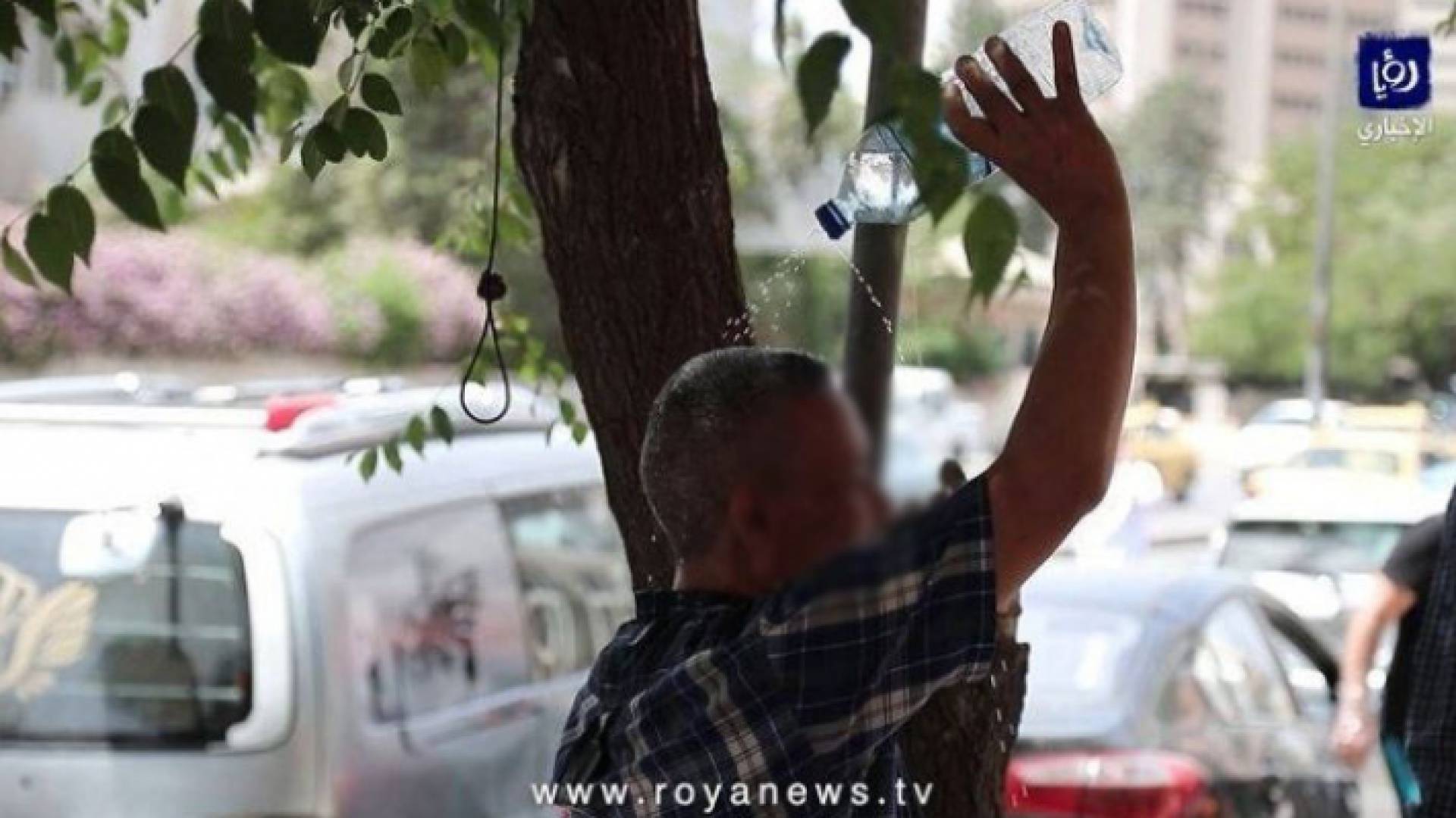 شخص يسكب المياه على رأسه في الأجواء الحارة