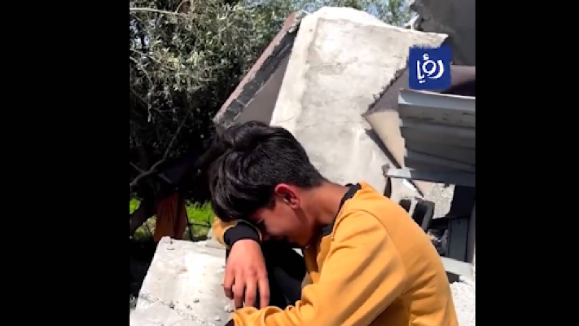 الطفل مجاهد طه يبكي أمام ركام منزله بعد قصفه