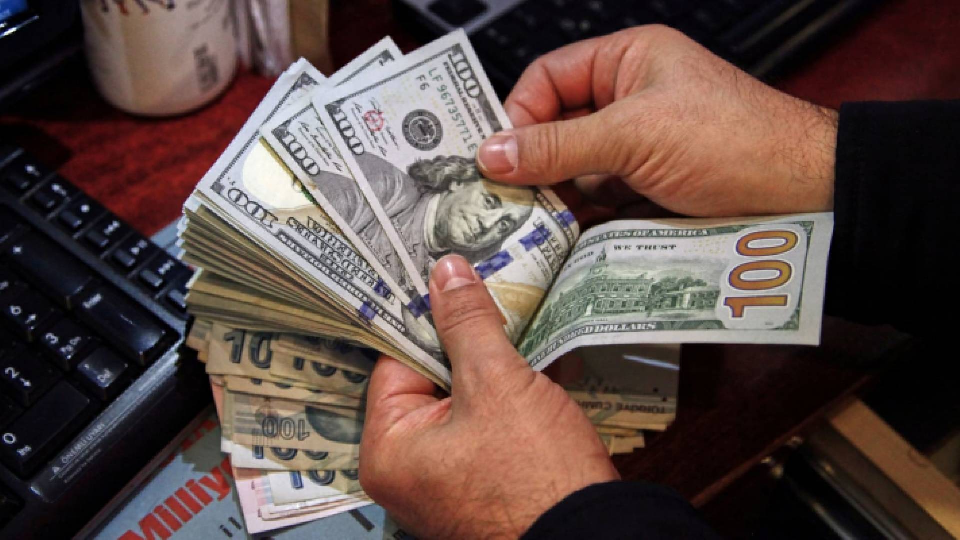 شخص يقوم بعد مبالغ كبيرة من الدولارات