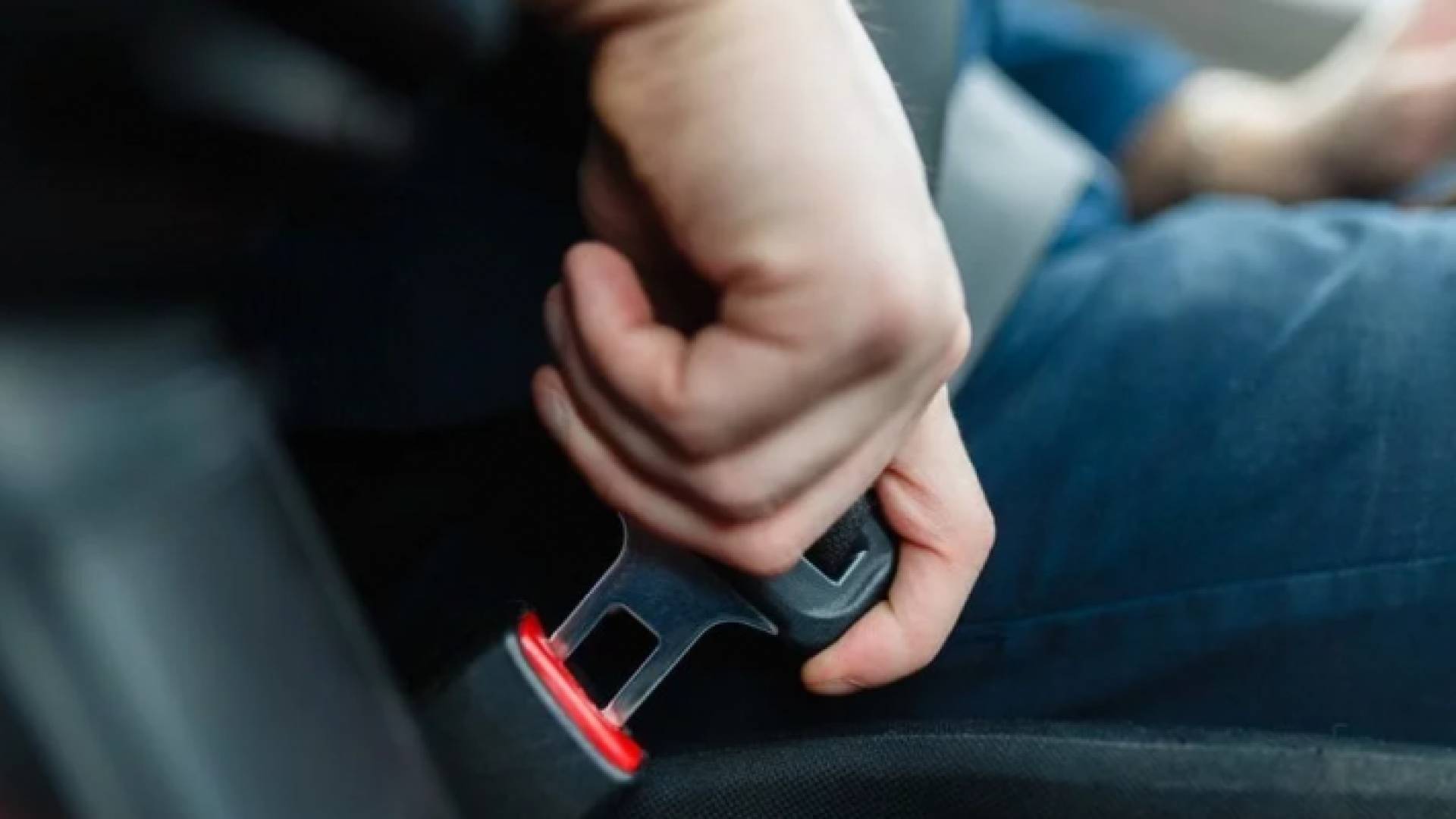 شخص يضع حزام الأمان في مركبته