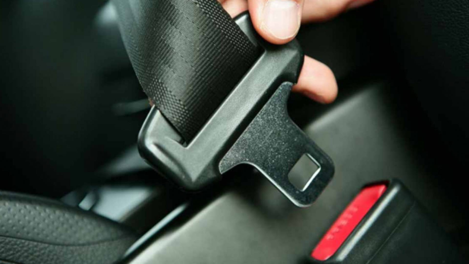 شخص يضع حزام الأمان في مركبته