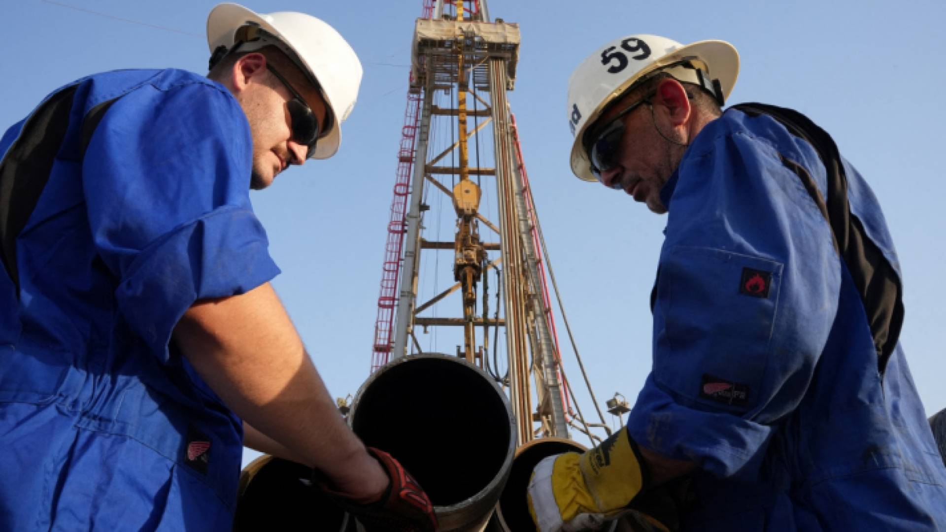 عاملان يتفحصان أنابيب لشركة الحفر العراقية في حقل الزبير النفطي بالبصرة