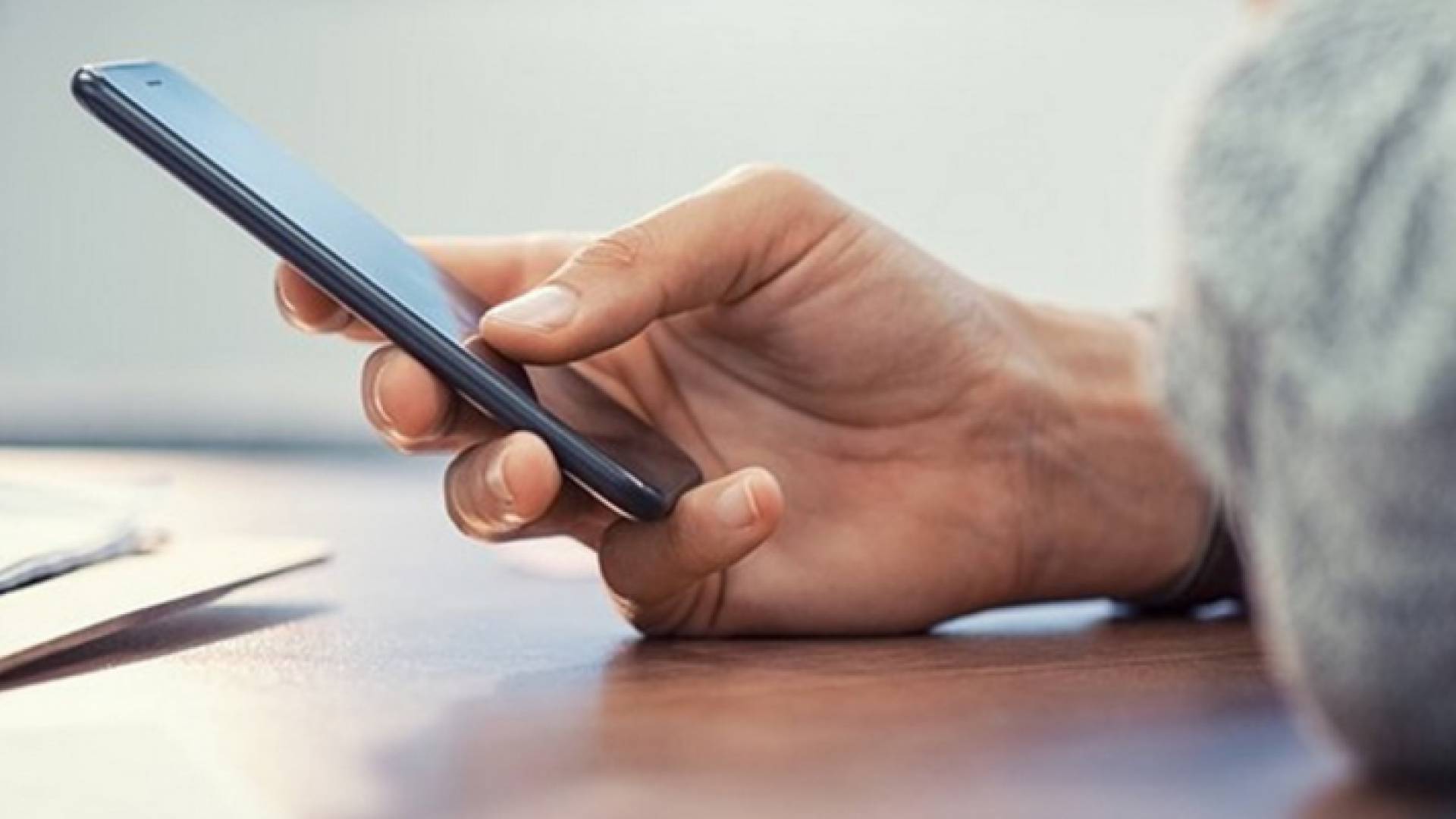 شخص يحمل هاتف خلوي "تعبيرية"