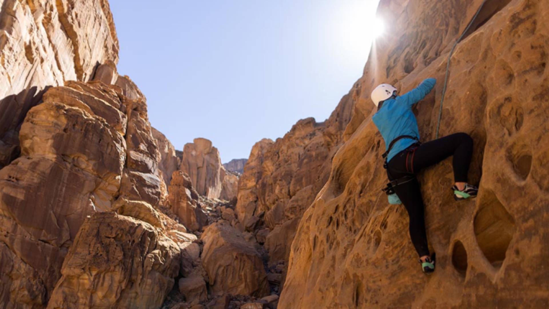 صورة لشخص يتسلق احد الجبال الصخرية