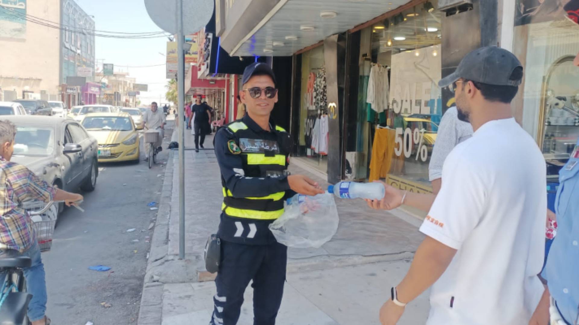 رجل من إدارة سير المفرق يوزع مياه على المواطنين