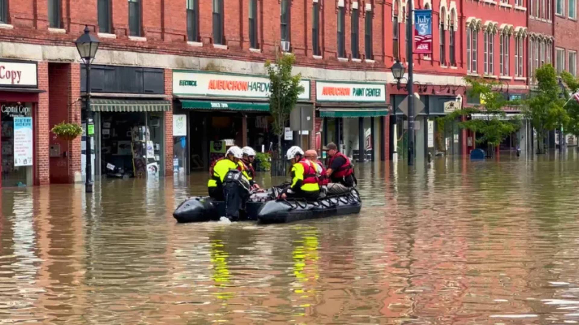 قارب يحاول إنقاذ أشخاص عالقين جراء الفيضانات
