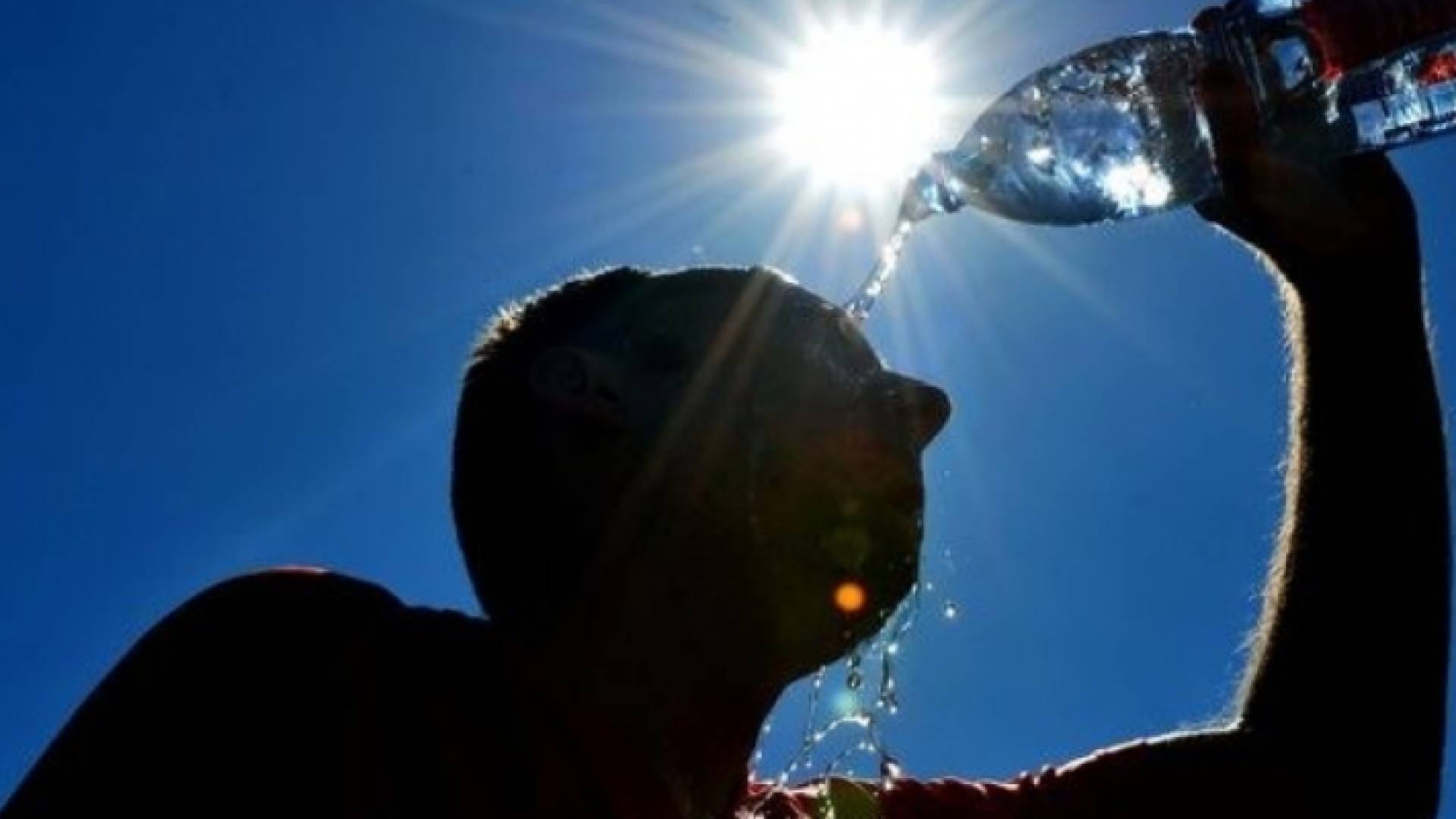 شخص يسكب الماء على وجهه لارتفاع درجات الحرارة