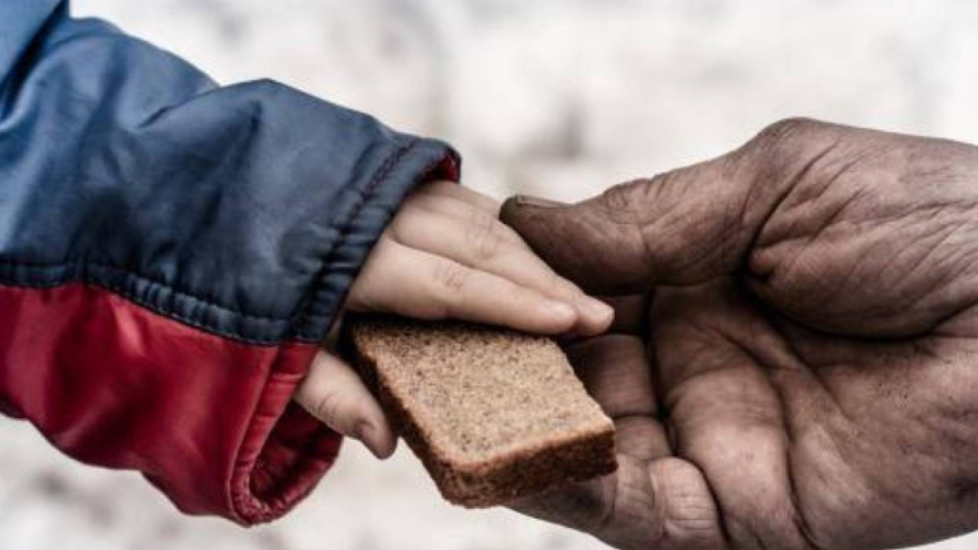 شخص يعطي طفلا قطعة "بسكوت"