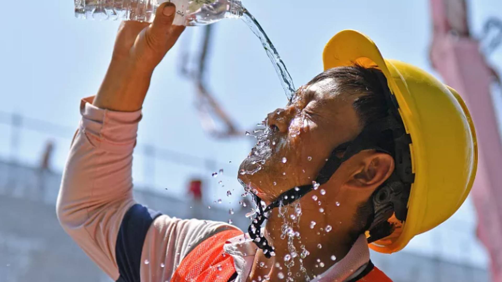 عامل صيني يسكب على موجهه الماء نتيجة لارتفاع درجات الحرارة