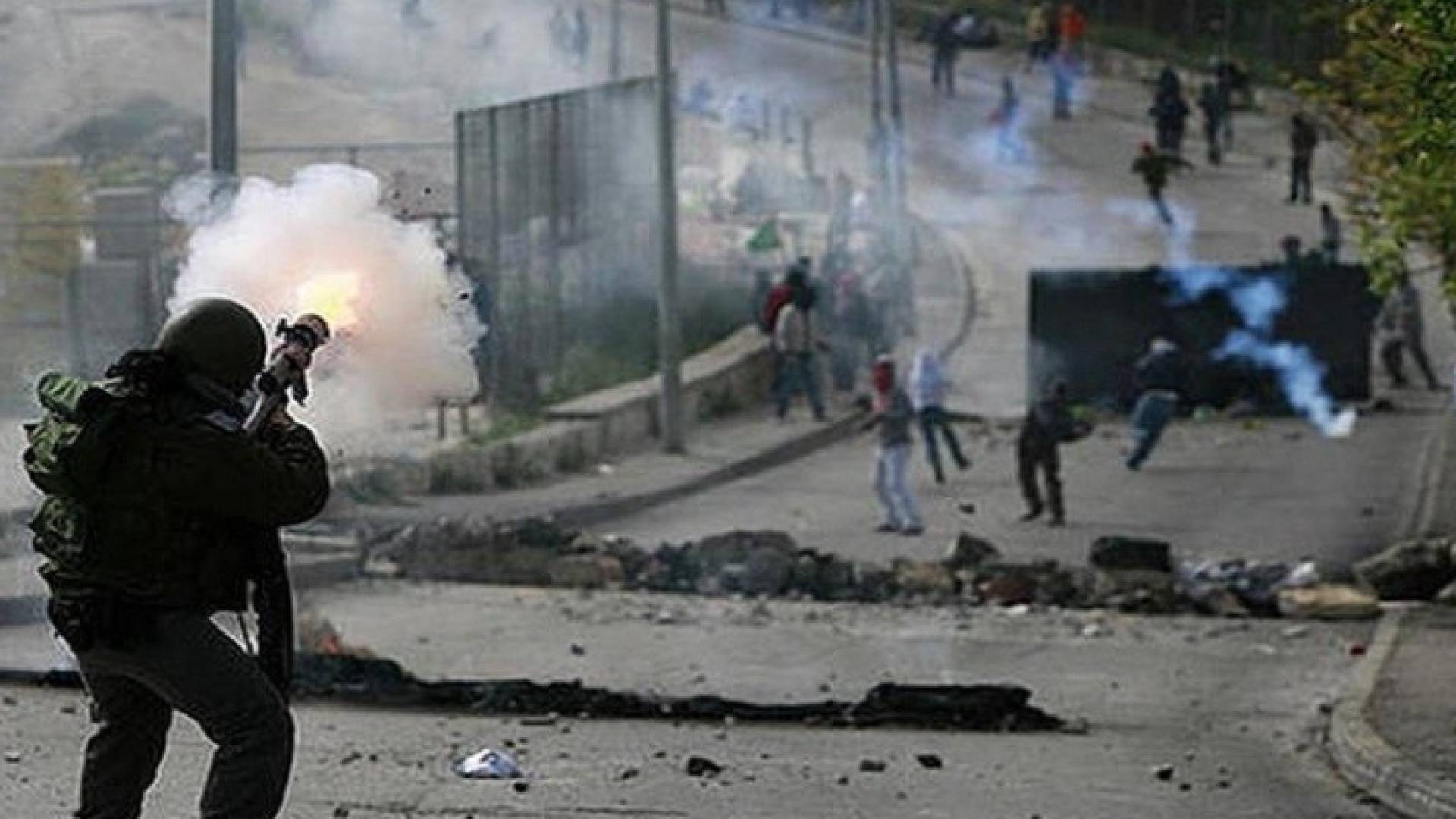 جندي من قوات الاحتلال يصوب سلاحه تجاه فلسطينيين