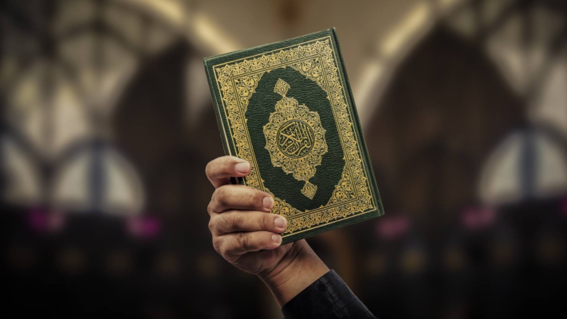 شخص يرفع نسخة من المصحف الشريف