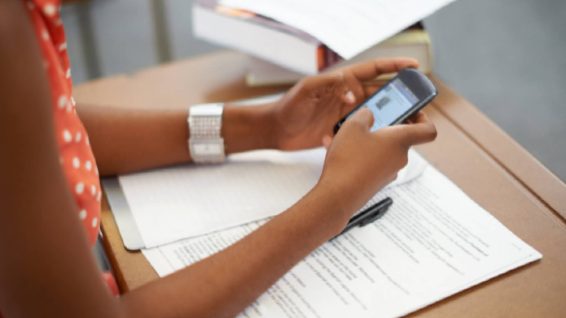 فتاة تمسك بهاتفها أثناء انعقاد امتحان - تعبيرةي