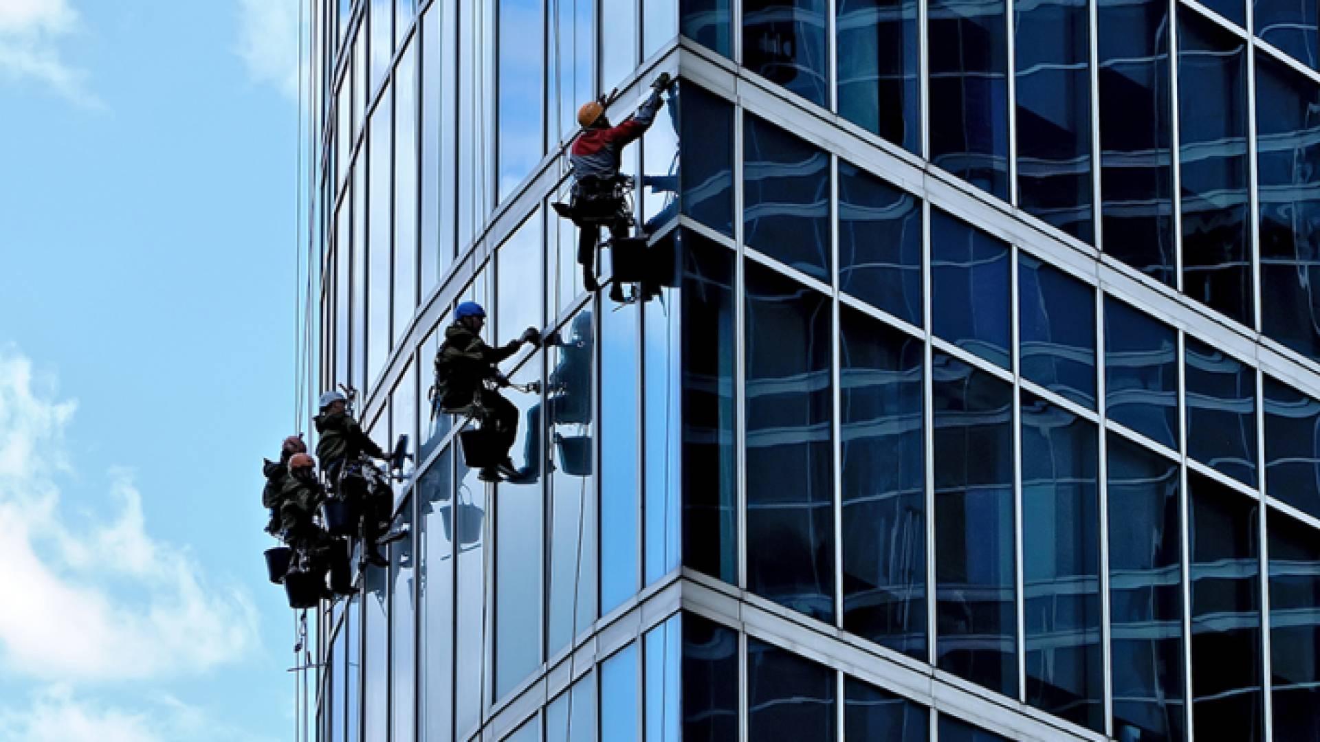 عاملون ينظفون واجهة إحدى الشركات