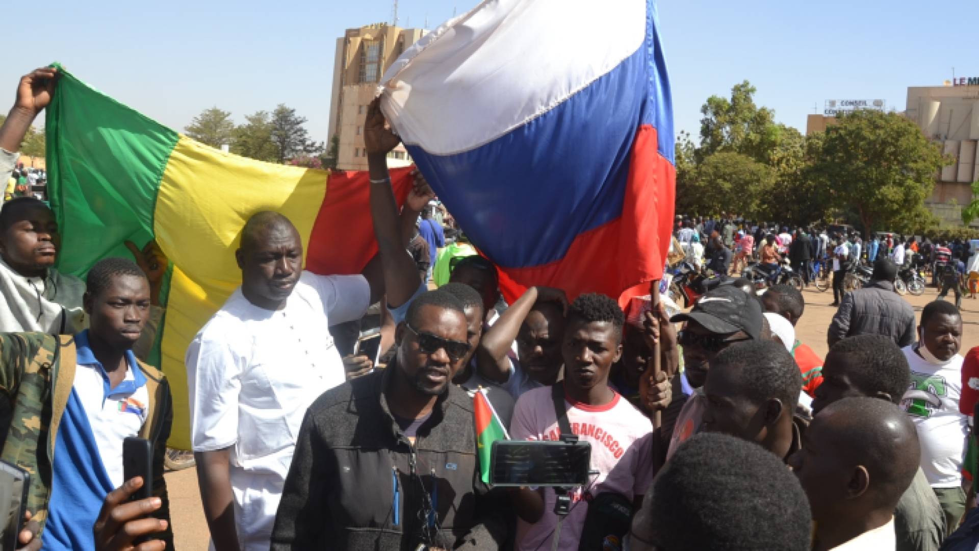 أشخاص يرفعون علمي بوركينا فاسو وفرنسا