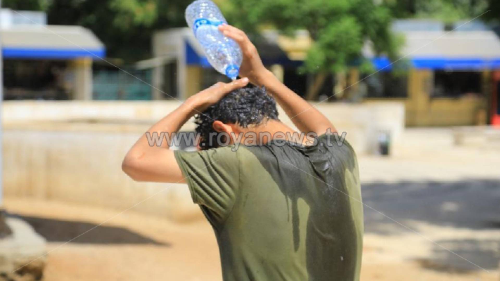 شخص يسكب الماء على رأسه من شدة الحرارة