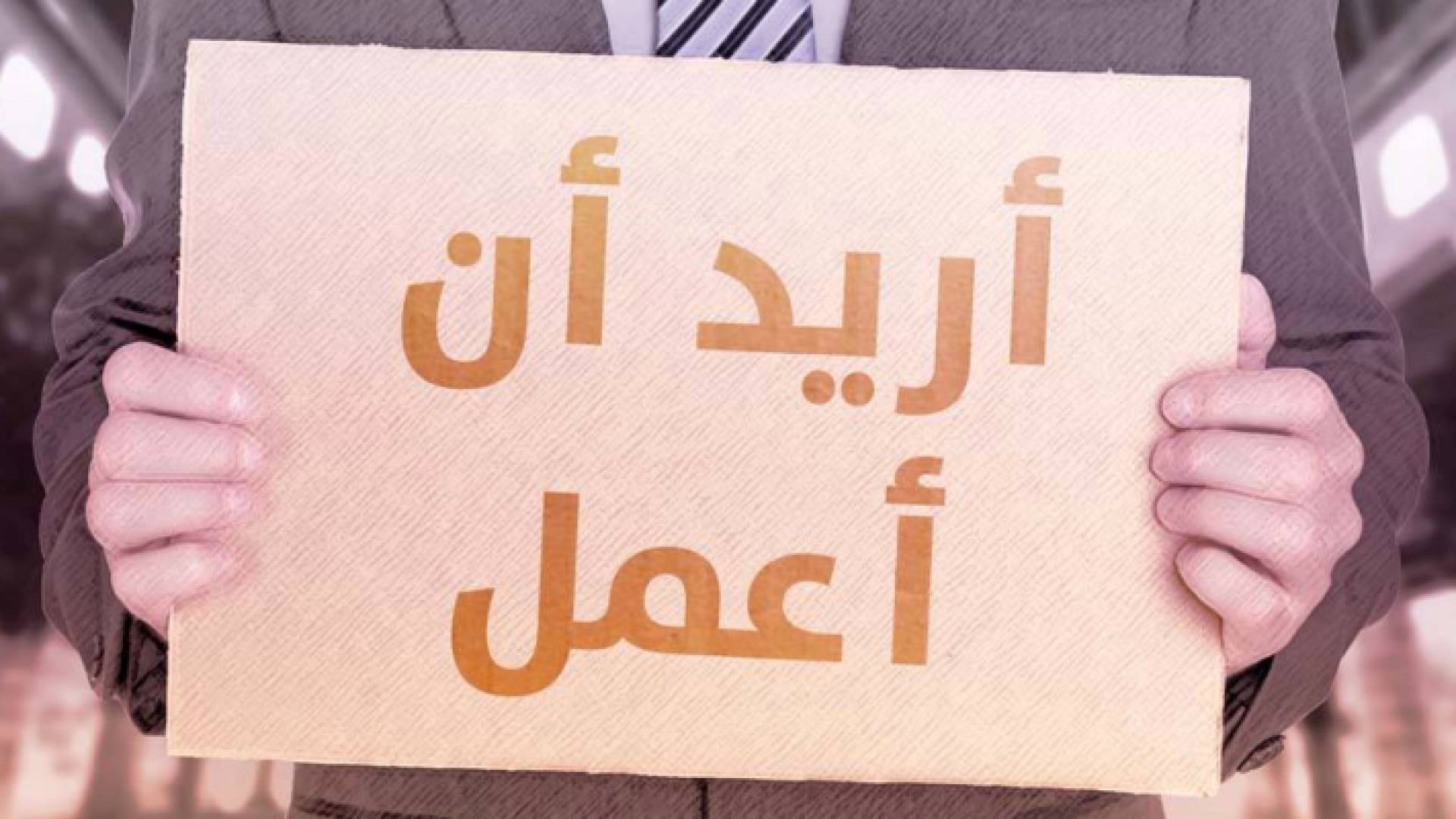 شخص يحمل يافطة تعبيرا عن استيائه من البطالة