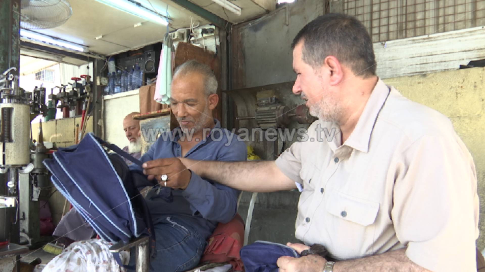 مواطن بجانب صاحب ورشة خياطة