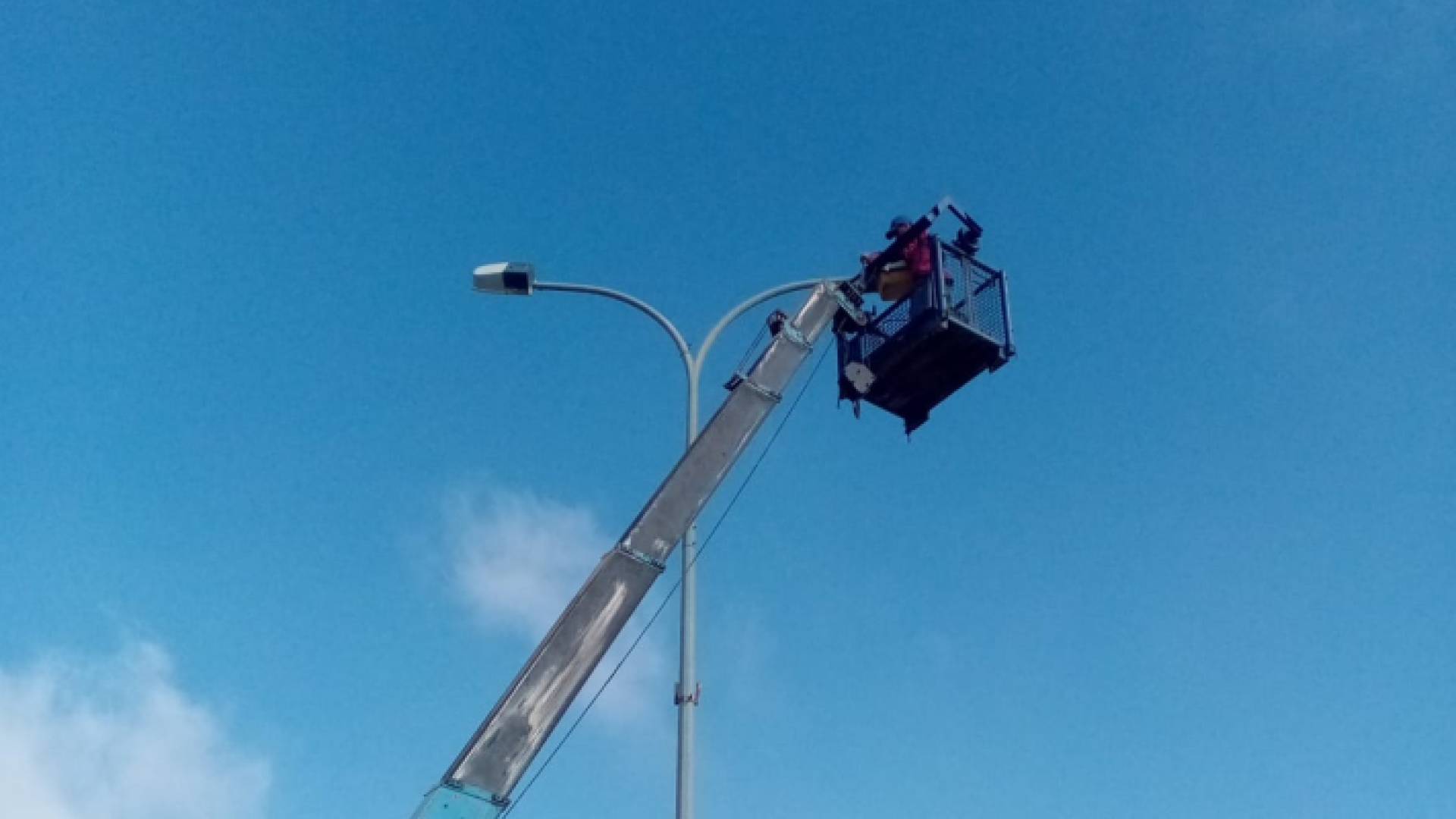 موظف يجري صيانة لأحد أعمدة الكهرباء