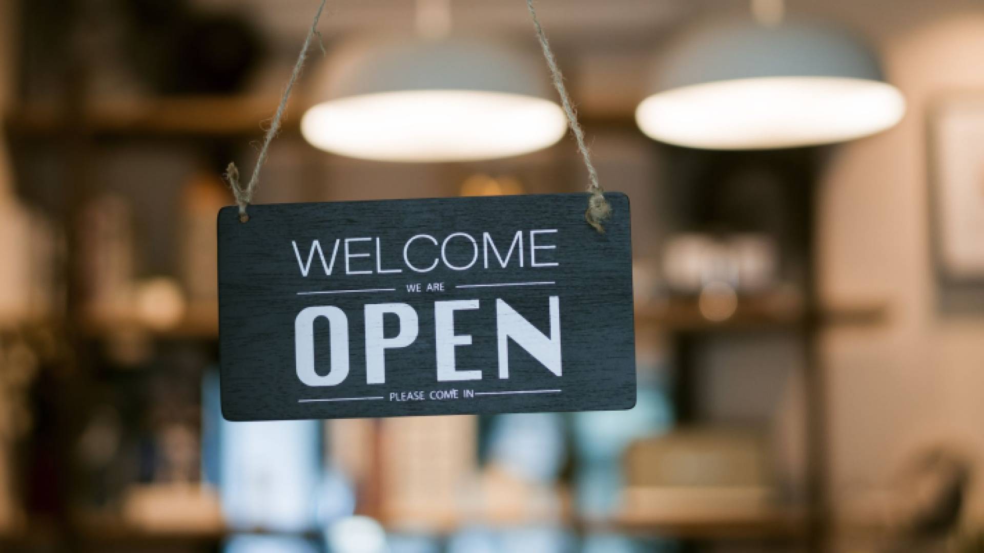 صورة تعبيرية لأحد المحل التجارية يضع يافطة (open)